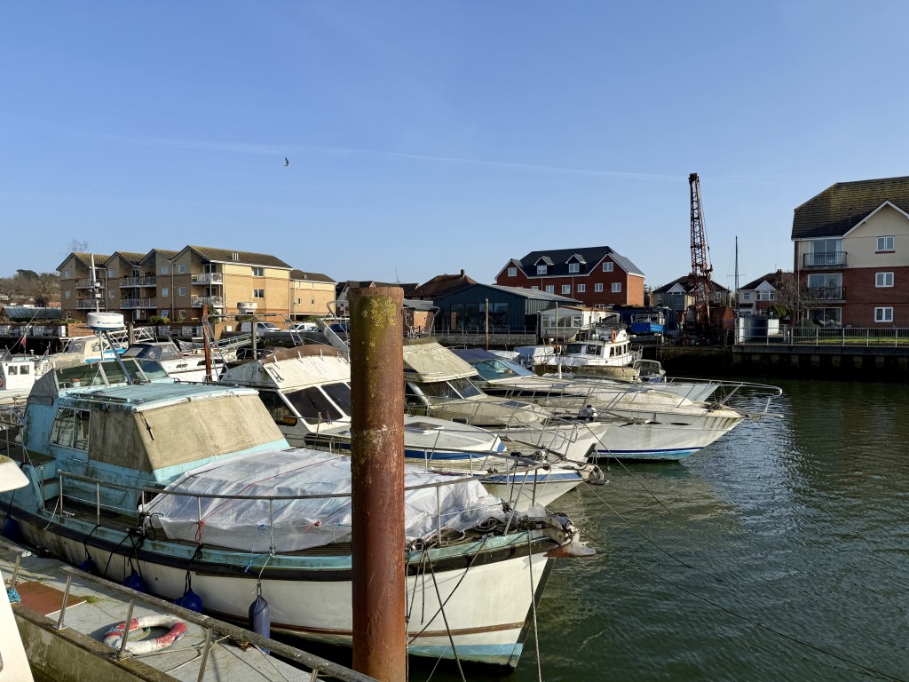 Lot: 99 - BOAT YARD WITH CONSENT FOR RESIDENTIAL DEVELOPMENT - Pontoon with boat yard in the background